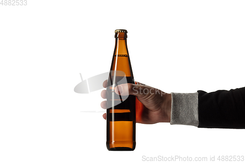 Image of Empty golden colored beer bottle in male hand. Isolated on white studio background