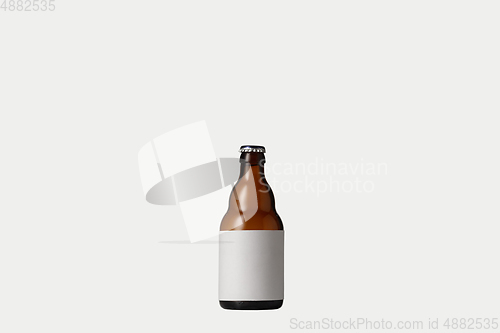 Image of Empty golden colored beer bottle. Isolated on white studio background