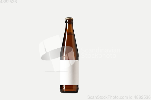 Image of Empty golden colored beer bottle. Isolated on white studio background