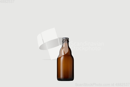 Image of Empty golden colored beer bottle. Isolated on white studio background