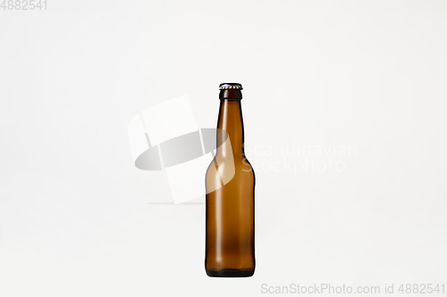 Image of Empty golden colored beer bottle. Isolated on white studio background