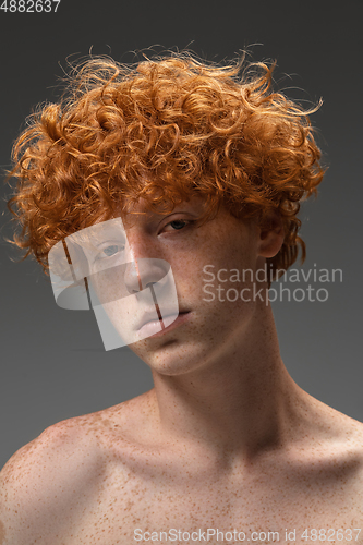 Image of Portrait of beautiful redhead man isolated on grey studio background. Concept of beauty, skin care, fashion and style