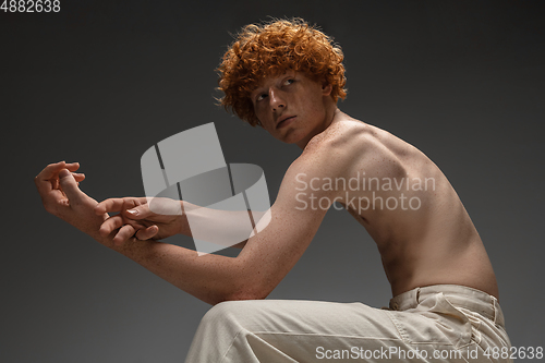 Image of Portrait of beautiful redhead man isolated on grey studio background. Concept of beauty, skin care, fashion and style