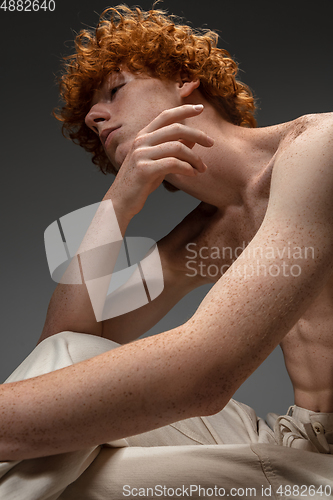 Image of Portrait of beautiful redhead man isolated on grey studio background. Concept of beauty, skin care, fashion and style