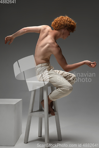 Image of Portrait of beautiful redhead man isolated on grey studio background. Concept of beauty, skin care, fashion and style