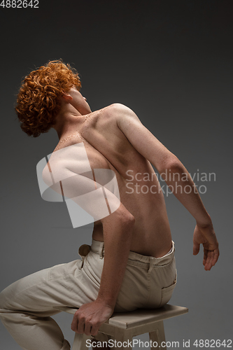 Image of Portrait of beautiful redhead man isolated on grey studio background. Concept of beauty, skin care, fashion and style