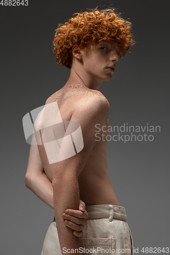 Image of Portrait of beautiful redhead man isolated on grey studio background. Concept of beauty, skin care, fashion and style