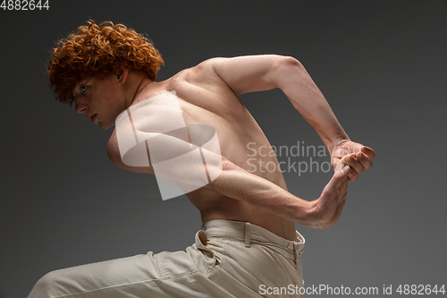 Image of Portrait of beautiful redhead man isolated on grey studio background. Concept of beauty, skin care, fashion and style