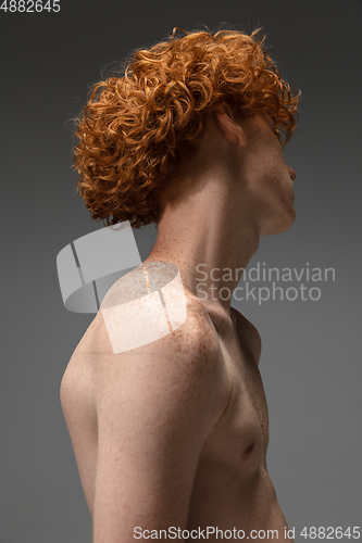 Image of Portrait of beautiful redhead man isolated on grey studio background. Concept of beauty, skin care, fashion and style