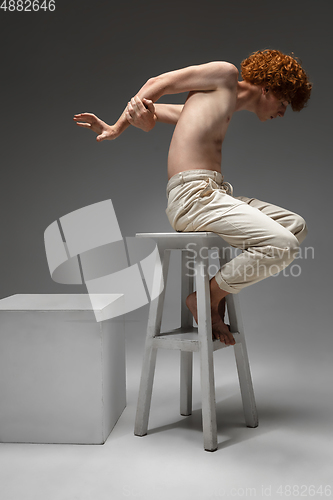 Image of Portrait of beautiful redhead man isolated on grey studio background. Concept of beauty, skin care, fashion and style