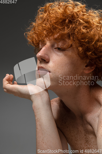 Image of Portrait of beautiful redhead man isolated on grey studio background. Concept of beauty, skin care, fashion and style