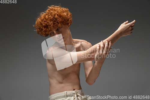 Image of Portrait of beautiful redhead man isolated on grey studio background. Concept of beauty, skin care, fashion and style