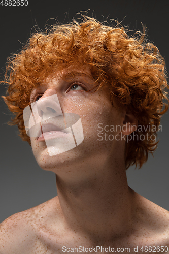 Image of Portrait of beautiful redhead man isolated on grey studio background. Concept of beauty, skin care, fashion and style