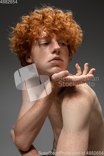 Image of Portrait of beautiful redhead man isolated on grey studio background. Concept of beauty, skin care, fashion and style