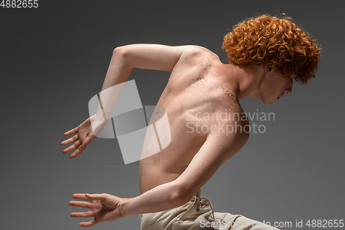 Image of Portrait of beautiful redhead man isolated on grey studio background. Concept of beauty, skin care, fashion and style