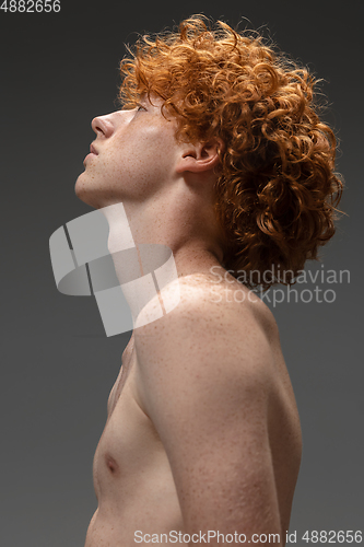 Image of Portrait of beautiful redhead man isolated on grey studio background. Concept of beauty, skin care, fashion and style