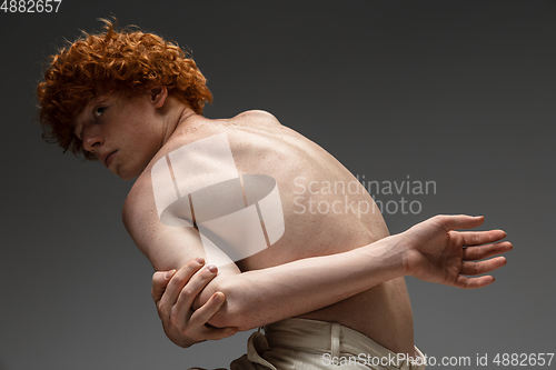 Image of Portrait of beautiful redhead man isolated on grey studio background. Concept of beauty, skin care, fashion and style