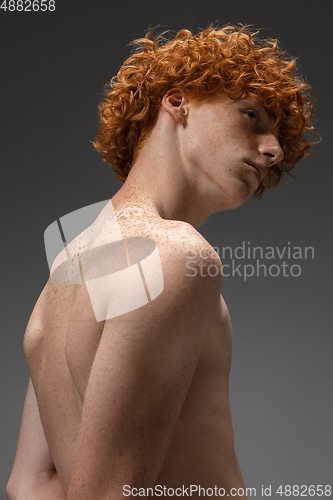 Image of Portrait of beautiful redhead man isolated on grey studio background. Concept of beauty, skin care, fashion and style