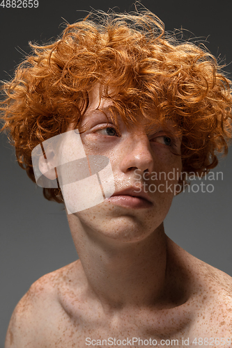 Image of Portrait of beautiful redhead man isolated on grey studio background. Concept of beauty, skin care, fashion and style