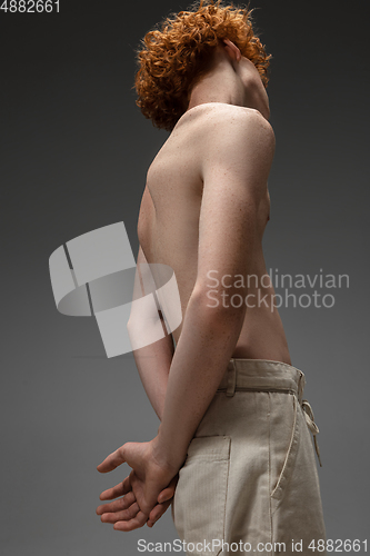 Image of Portrait of beautiful redhead man isolated on grey studio background. Concept of beauty, skin care, fashion and style