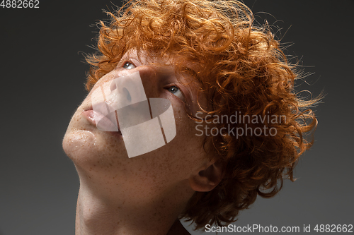 Image of Portrait of beautiful redhead man isolated on grey studio background. Concept of beauty, skin care, fashion and style