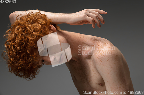 Image of Portrait of beautiful redhead man isolated on grey studio background. Concept of beauty, skin care, fashion and style