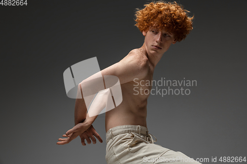 Image of Portrait of beautiful redhead man isolated on grey studio background. Concept of beauty, skin care, fashion and style