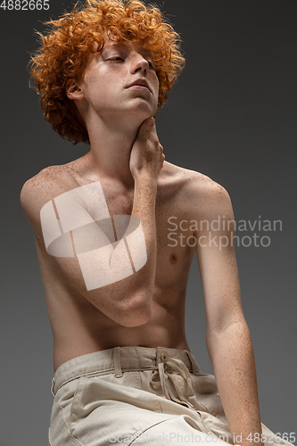 Image of Portrait of beautiful redhead man isolated on grey studio background. Concept of beauty, skin care, fashion and style