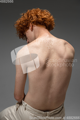 Image of Portrait of beautiful redhead man isolated on grey studio background. Concept of beauty, skin care, fashion and style
