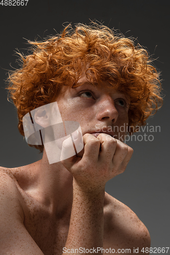 Image of Portrait of beautiful redhead man isolated on grey studio background. Concept of beauty, skin care, fashion and style