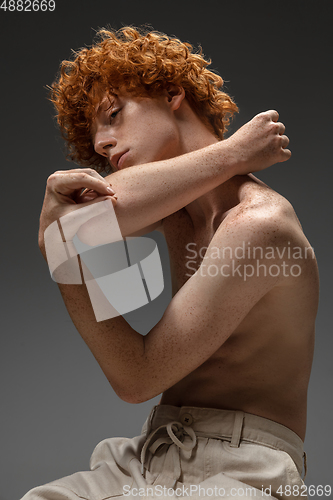 Image of Portrait of beautiful redhead man isolated on grey studio background. Concept of beauty, skin care, fashion and style