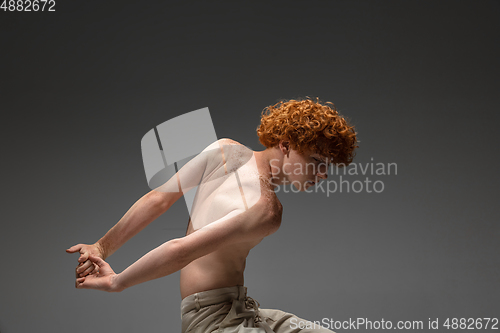 Image of Portrait of beautiful redhead man isolated on grey studio background. Concept of beauty, skin care, fashion and style