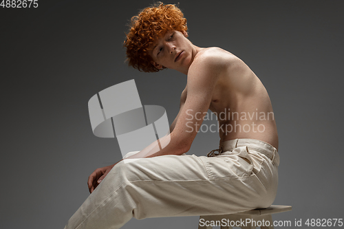 Image of Portrait of beautiful redhead man isolated on grey studio background. Concept of beauty, skin care, fashion and style