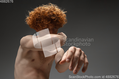 Image of Portrait of beautiful redhead man isolated on grey studio background. Concept of beauty, skin care, fashion and style