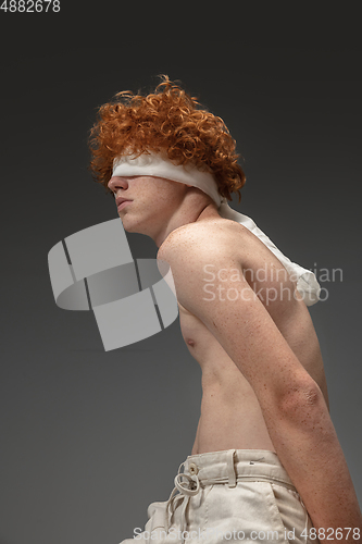 Image of Portrait of beautiful redhead man isolated on grey studio background. Concept of beauty, skin care, fashion and style