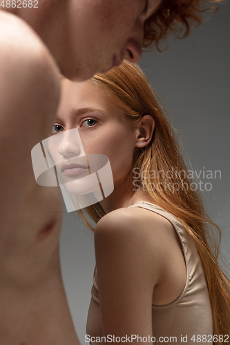 Image of Portrait of beautiful redhead couple isolated on grey studio background. Concept of beauty, skin care, fashion and style