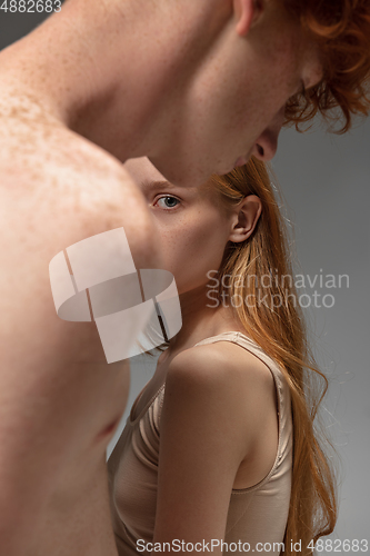 Image of Portrait of beautiful redhead couple isolated on grey studio background. Concept of beauty, skin care, fashion and style