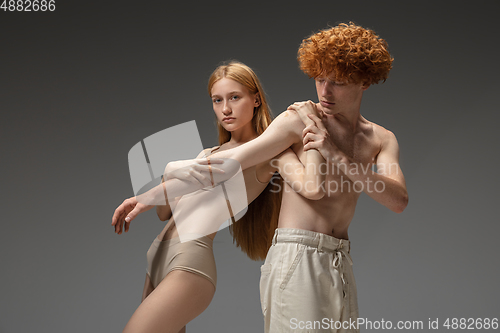 Image of Portrait of beautiful redhead couple isolated on grey studio background. Concept of beauty, skin care, fashion and style