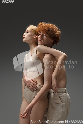 Image of Portrait of beautiful redhead couple isolated on grey studio background. Concept of beauty, skin care, fashion and style