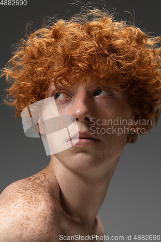 Image of Portrait of beautiful redhead man isolated on grey studio background. Concept of beauty, skin care, fashion and style