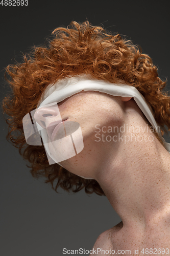 Image of Portrait of beautiful redhead man isolated on grey studio background. Concept of beauty, skin care, fashion and style