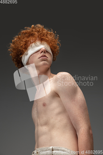 Image of Portrait of beautiful redhead man isolated on grey studio background. Concept of beauty, skin care, fashion and style