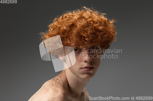 Image of Portrait of beautiful redhead man isolated on grey studio background. Concept of beauty, skin care, fashion and style