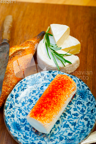 Image of French cheese and fresh  baguette on a wood cutter