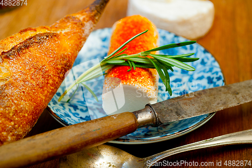 Image of French cheese and fresh  baguette on a wood cutter