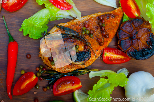 Image of wood fired hoven cooked chicken breast on wood board