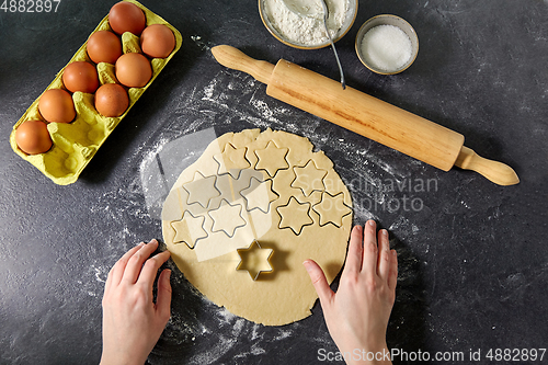 Image of hands with shortcrust pastry dough and star mold