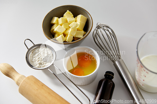 Image of rolling pin, butter, eggs, flour, milk and whisk