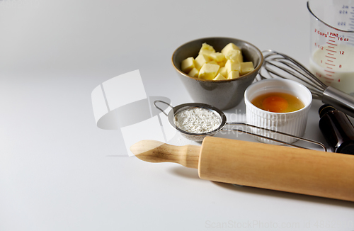 Image of rolling pin, butter, eggs, flour, milk and whisk