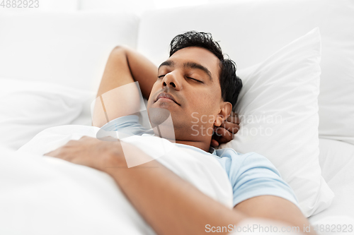 Image of indian man sleeping in bed at home